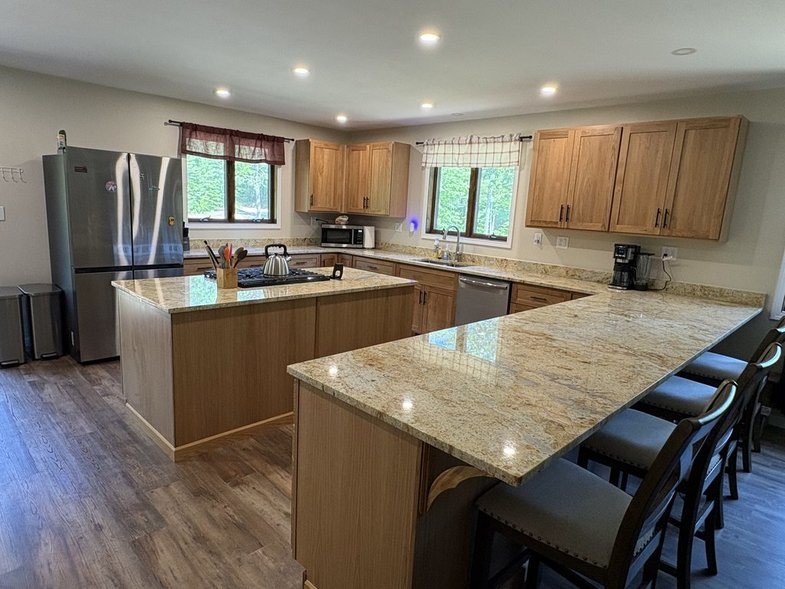 Large kitchen with granite counters, island cooktop and peninsula seating