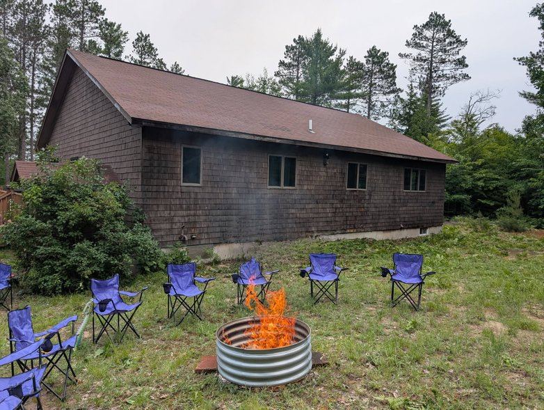 Firepit with camp chairs behind the cabin
