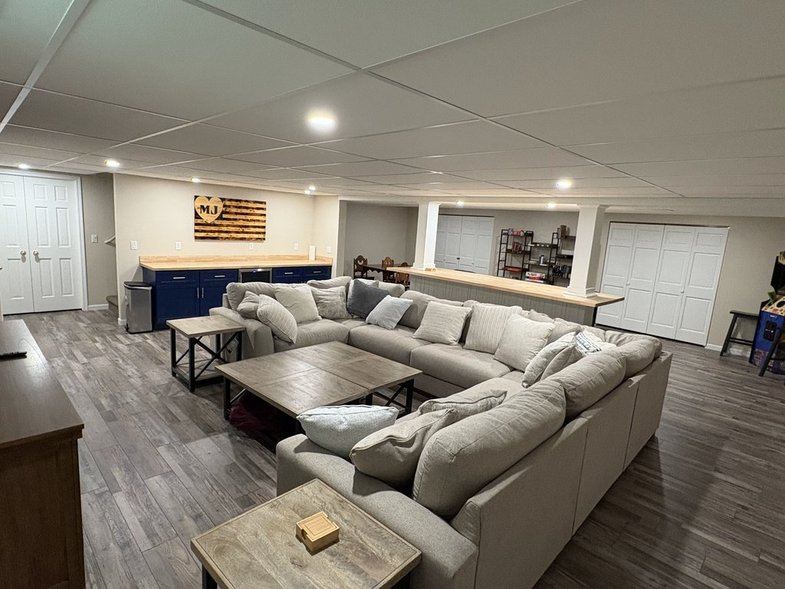 Lower-level family room with sectional and kitchenette counter